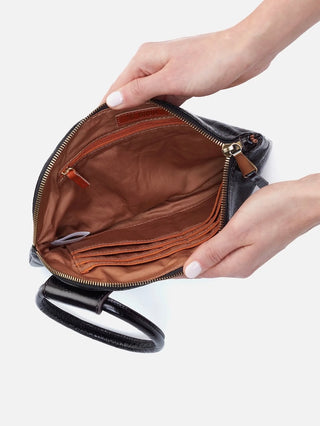 a leather clutch in black with a vintage circular handle featuring card slots and a zipper pocket