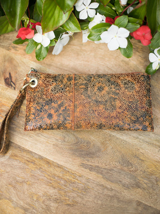 a penny brown leather wristlet with trendy textured patterns and designated compartments perfect for fall and winter fashion