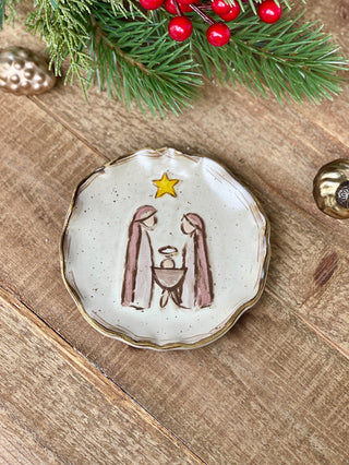 a stoneware holiday trinket dish with a manger image