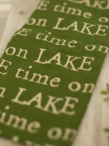 a green cotton hand towel reading lake time