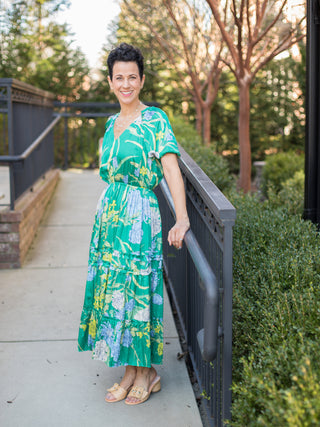 v neck island green floral midi dress with short puff sleeves worn with sand colored sandals