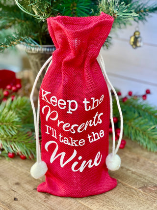 a fun red wine gift bag that says keep the presents i will take the wine