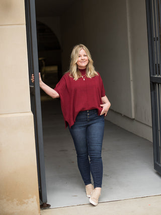 a burgundy short sleeve top with a mock turtleneck and loose short sleeves great for casual holiday outfits with dark denim