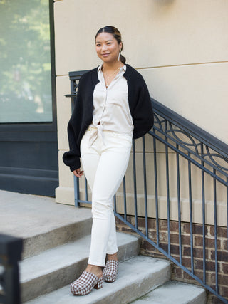 a black crop cardigan with puff sleeves and ribbed fabric with dancer chic style shown with white pants