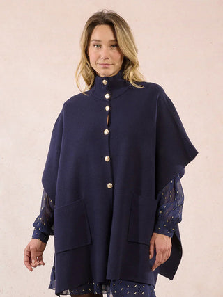 an oversized navy blue knit cap with a high neck front buttons and large pockets