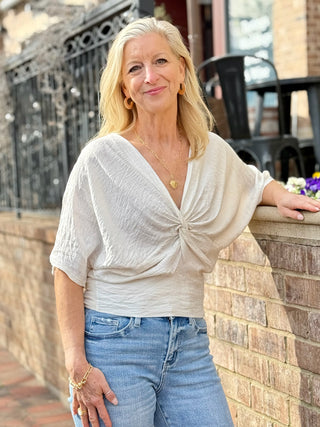 a chic white colored blouse with a deep v neck and twist detail