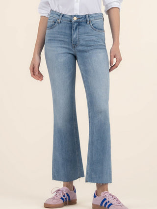 a pair of high rise ankle flare light wash blue denim jeans with a raw hem