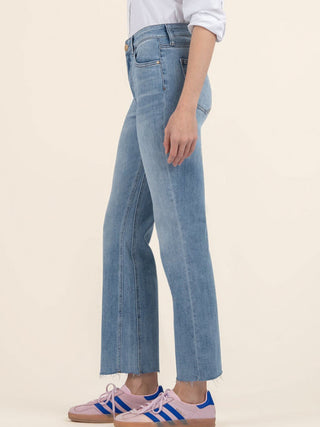 a pair of high rise ankle flare light wash blue denim jeans with a raw hem