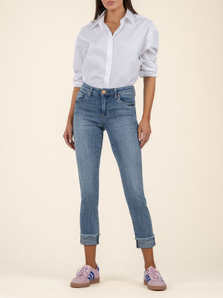 soft stretchy medium wash cropped denim jeans with a cuffed frayed hem worn with a white shirt