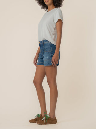 a pair of denim jean shorts with squared pockets worn with a white tee