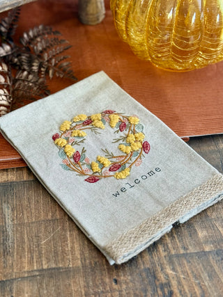 tan tea towel with festive autumn wreath embroidery