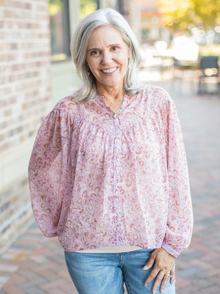 a pale pink chiffon blouse in a subtle print with long sleeves perfect for feminine fashion in every season 