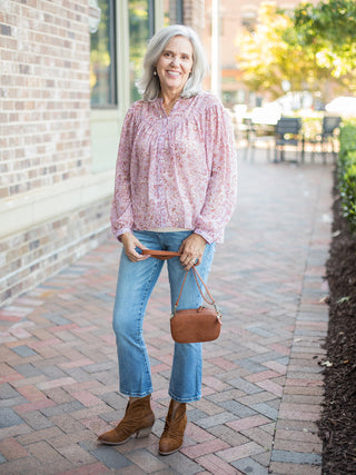 a pale pink chiffon blouse in a subtle print with long sleeves perfect for feminine fashion in every season shown with denim