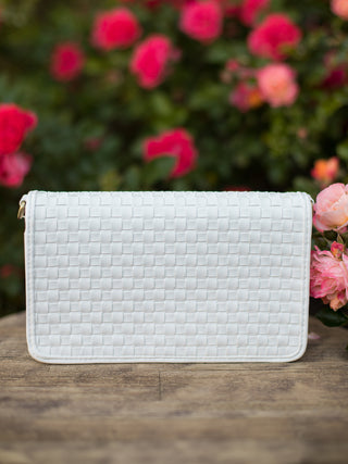 a white woven crossbody bag with a rear phone pocket built in credit card pockets and multiple compartments