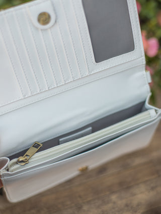 a white woven crossbody bag with a rear phone pocket built in credit card pockets and multiple compartments