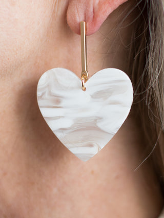 a pair of white marble statement earrings with an oversized heart charm and gold bar