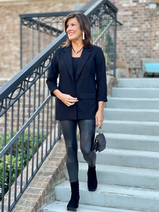 a black boyfriend blazer with structured shoulders and a statement collar shown with faux leather leggings