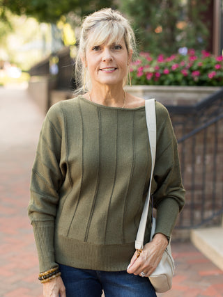 a forest green sweater with a boat neckline and flattering stitching perfect for summer to fall fashion