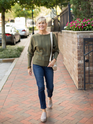 a forest green sweater with a boat neckline and flattering stitching perfect for summer to fall fashion shown with denim