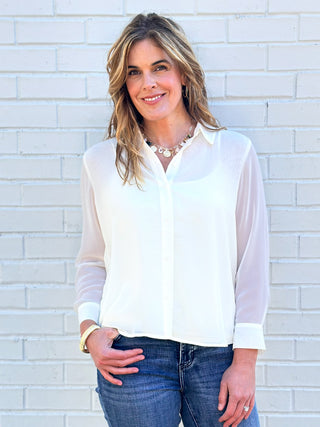 a soft ivory long sleeve blouse with a flowing pleated back