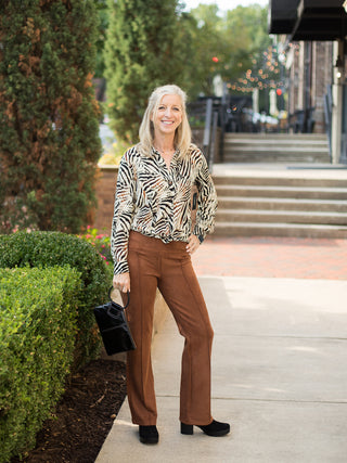 a pair of penny brown pants in faux suede with a seventies silhouette perfect for fall fashion shown with a zebra blouse