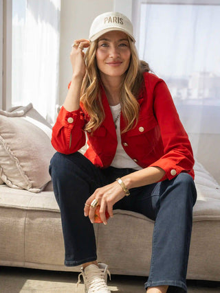 a bright red button front collared peplum jacket worn with a white top and blue jeans