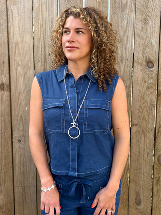 a blue sleeveless cargo shirt with collar and front pockets and hidden buttons