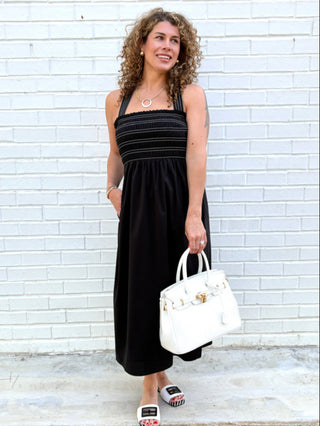 a black mini dress with a smocked bodice and removable straps