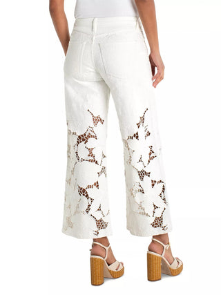 White pants with brown floral pattern worn by a person on a white background