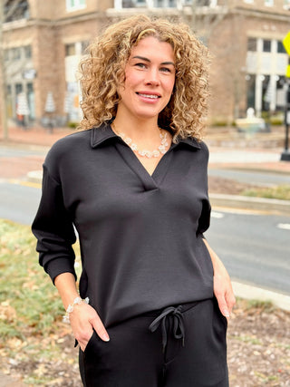 a black long sleeve pull over collared sweater