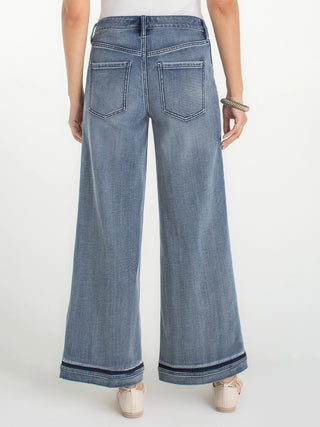 a pair of light wide leg lengthening denim jeans with a tonal shading at the seam