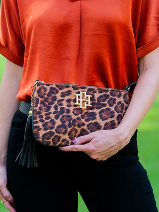 a bold cheetah spotted crossbody bag with gold accents and a black tassel zipper