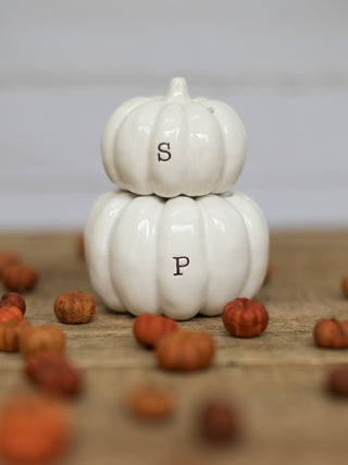 a pair of white ceramic pumpkin shakers for salt and pepper with magnetic properties perfect for fall decor gifts