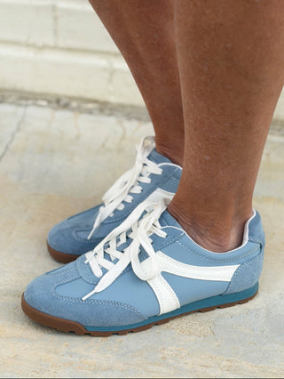 a pair of chic powder blue suede sneakers with white laces