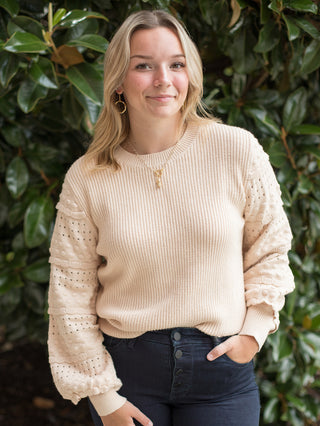 a light beige sweater with long statement sleeves and romantic ruffles featuring a high scoop neckline great for fall fashion