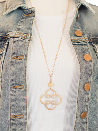 a gold boho statement necklace with a flower pendant