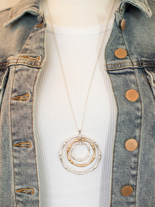 a mixed metal boho statement necklace with silver and gold circle pendants