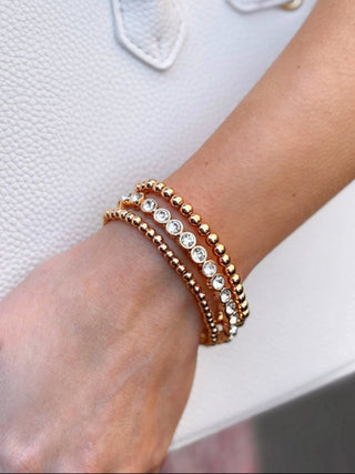 a charming set of three stretch bracelets with gold beads and rhinestones