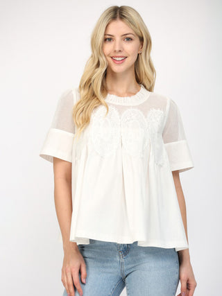 white mesh short sleeve top with appliqué details and ruffled neckline