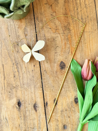 a gold metal floral butterfly pick for a vase