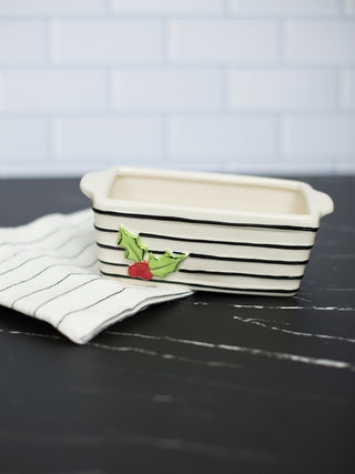 a beige christmas holly loaf pan with a striped towel perfect for holiday home decor and as host gifts