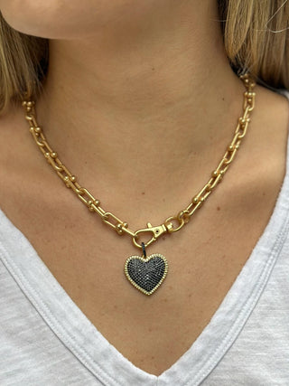a chunky gold chain necklace with a black pave heart charm
