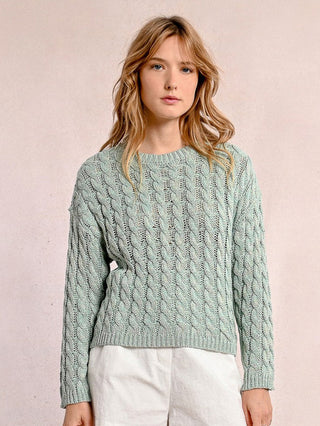 a classic turquoise pastel cable knit sweater with a subtle metallic finish