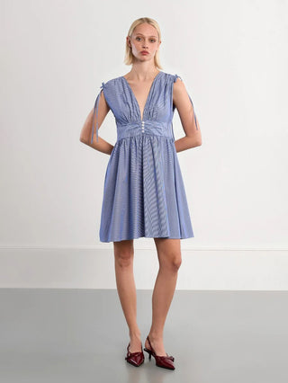Woman wearing a blue dress against a white background