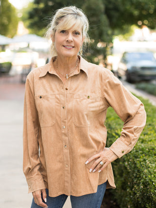 a tan button down shirt in suede with long sleeves and large pockets perfect for summer to fall fashion and as a casual layer