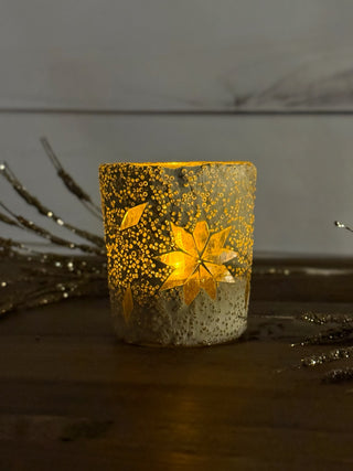 a white mosaic votive snowflake candle illuminated warm light in the dark