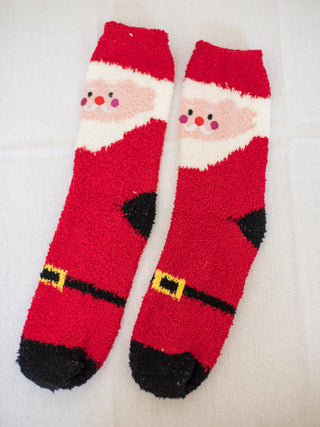 a pair of fuzzy santa claus christmas socks perfect for holiday gifts and as stocking stuffer presents