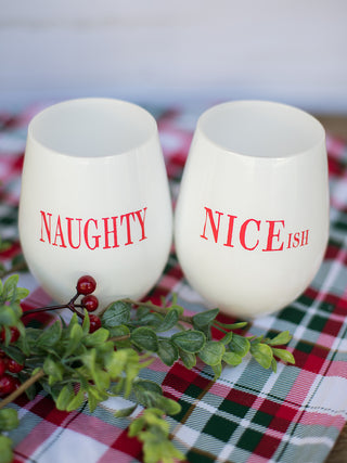 a pair of white and red stemless christmas wine glasses that read naughty and niceish perfect as funny stocking stuffer gift