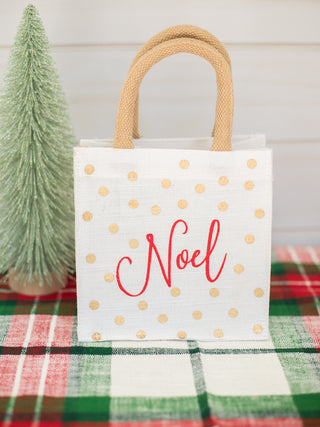 a white and gold christmas present bag with noel in red perfect for holiday festivities and host gifts