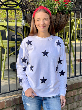 cozy white sweatshirt adorned with dark blue embroidered stars and the words oh my stars